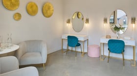 Bridal suite featuring vanity tables, blue velvet chairs, and gold décor accents at Canopy Grove in Escondido, CA.