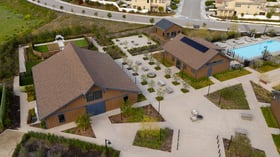 Wide aerial view of Canopy Grove showcasing the ceremony lawn, barn reception hall, and landscaped outdoor courtyards.