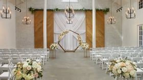 Elegant Carlsbad Windmill wedding chapel with floral arch and white seating for ceremony.