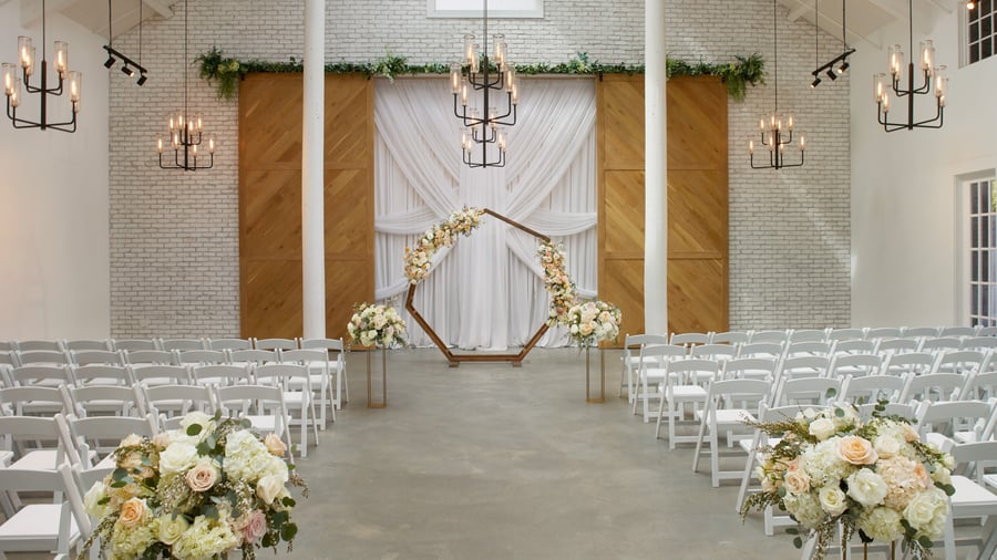 Elegant Carlsbad Windmill wedding chapel with floral arch and white seating for ceremony.