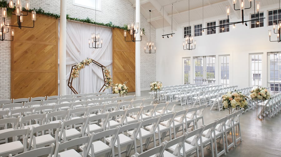 Side view of Carlsbad Windmill wedding chapel with floral aisle arrangements and white chairs.