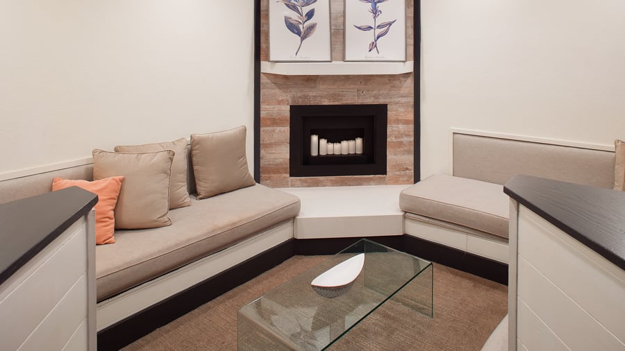 Cozy lounge area in Carlsbad Windmill Garden Suite with fireplace and neutral decor.