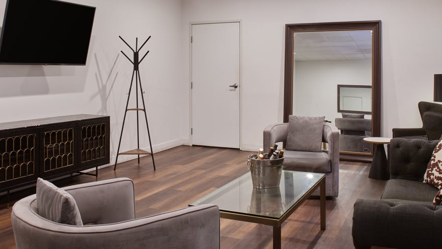 Groom’s room in Carlsbad Windmill Garden Suite with seating, TV, and modern accents.