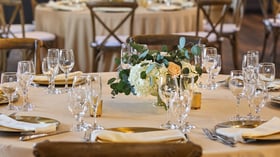 Floral centerpiece with white and peach roses at Carlsbad Windmill Loft wedding reception.