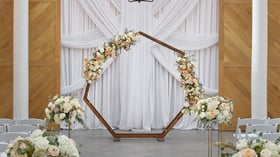 Close-up of floral hexagon arch inside Carlsbad Windmill wedding chapel ceremony space.
