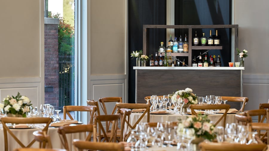 Full-service bar inside Colby Falls Grand Hall Arizona, surrounded by reception tables with elegant place settings and floral centerpieces.