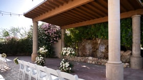 Grand Waterfall ceremony space at Colby Falls Arizona featuring stone pillars, cascading waterfall, floral arrangements, and guest seating.