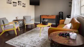 Modern Lounge Suite at Cuvier Club La Jolla featuring leather seating, foosball table, flat-screen TV, and mid-century modern furniture for pre-wedding relaxation