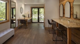 Spacious preparation room in Galway Downs Wedding Suites featuring granite vanity counters, rustic wood accents, natural lighting, and garden views for getting ready in Temecula