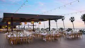  Twilight reception setup with string lights and coastal cliff views