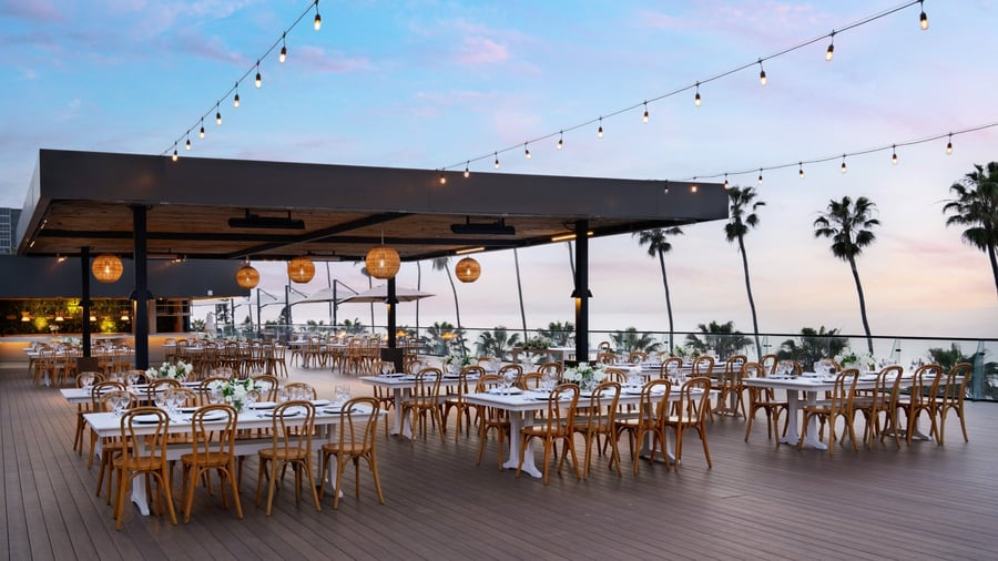  Twilight reception setup with string lights and coastal cliff views