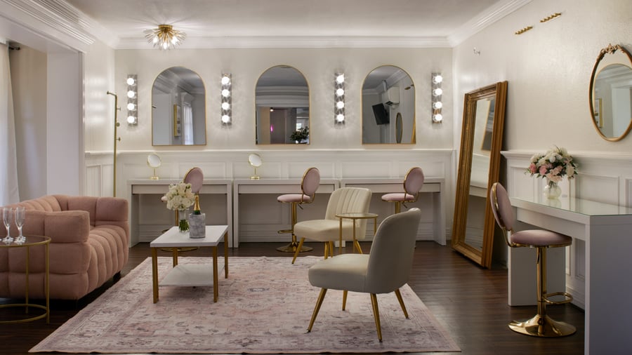 Stylish bridal suite at Lindsay Grove in Mesa, AZ featuring vanity stations, blush seating, mirrors, floral décor, and modern lighting.