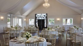 Indoor wedding reception setup at Lindsay Grove Grand Hall in Mesa, AZ with floral centerpieces, chandeliers, and formal banquet seating.