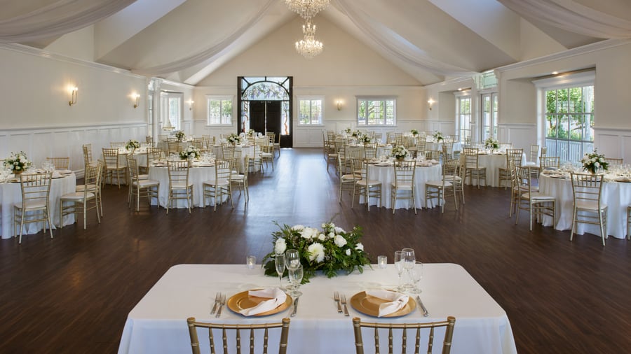 Sophisticated reception at Lindsay Grove Grand Hall in Mesa, AZ with crystal chandeliers, high ceilings, and elegant round tables with floral décor.