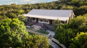Aerial view of Scenic Springs wedding venue in Helotes, Texas, surrounded by lush green trees and stone walkways.