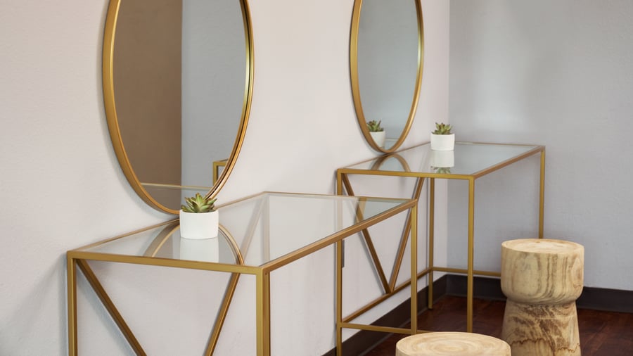 Stylish vanity setup at The Pines with two gold-framed mirrors, glass tables, and natural wood stools, perfect for bridal party preparations.