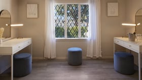 Bright wedding suite vanity area at The Sanctuary in Long Beach with matching mirrors, seating, and diamond-pane windows