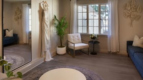 Bridal dressing room at The Sanctuary in Long Beach with wedding gown on display, full-length mirror, and seating area