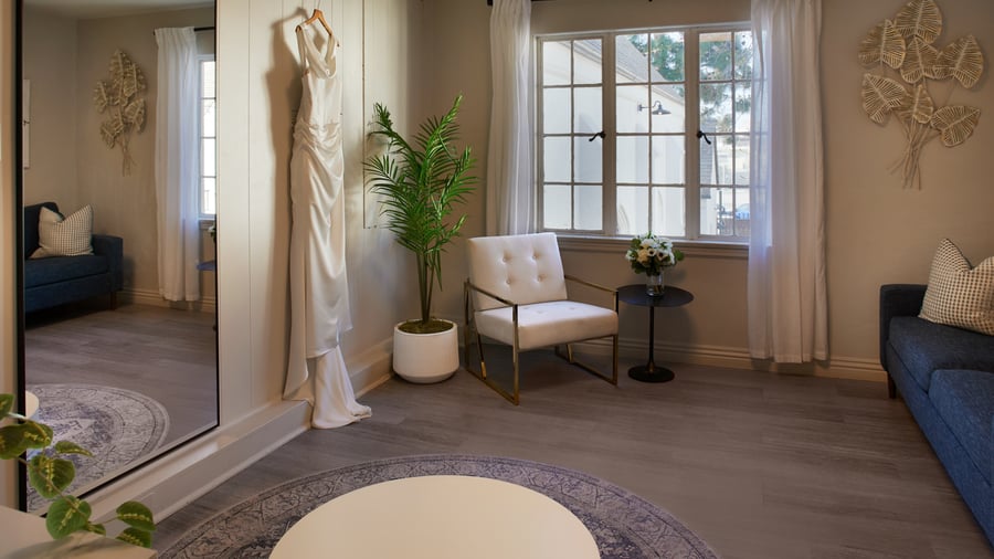 Bridal dressing room at The Sanctuary in Long Beach with wedding gown on display, full-length mirror, and seating area