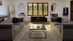Groom’s lounge suite at The Sanctuary in Long Beach with leather seating, game table, and stained glass windows.