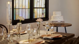 Sweetheart table in The Sanctuary Grand Hall, Long Beach, with white floral backdrop and gold accents.