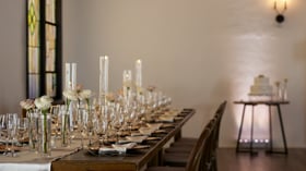 Long head table at The Sanctuary Grand Hall wedding reception with cascading floral runner and candlelight.