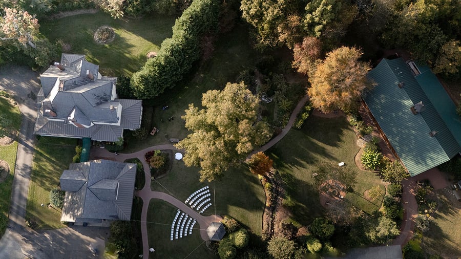 Aerial view of Alexander Homesteads multiple event buildings and ceremony spaces surrounded by mature trees in Charlotte, NC