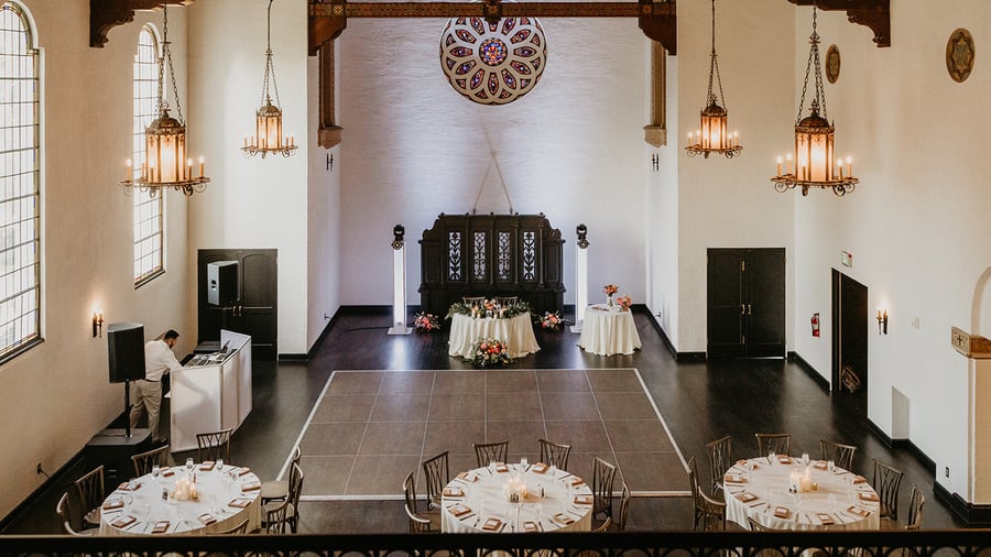 Vintage style indoor banquet hall with hard oak wood floors that pair with white washed walls and stained glass at Fillmore Chapel by Wedgewood Events
