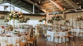 Elaborate floral centerpieces complement industrial stylings at this indoor reception at Clayton House by Wedgewood Events