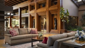 Grand lobby lounge with dramatic architectural wood detailing, towering ceilings, elegant sitting areas, and artisanal decor elements offering sophisticated gathering spaces for wedding guests
