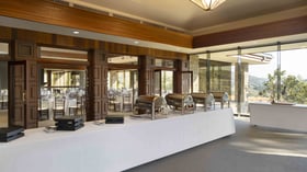 Premier buffet setup area overlooking the main ballroom with elegant French doors and mountain vistas, providing seamless catering service for wedding receptions