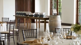 Rustic event catering station at Fallbrook Estate by Wedgewood Events featuring wooden serving tables, wine barrel accent, warming trays for corporate events and private celebrations in Spanish colonial venue