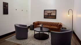 Elegant executive event room at Fallbrook Estate Wedgewood Events with leather Chesterfield seating, modern chairs, artwork and comfortable lounge area for corporate meetings and private gatherings