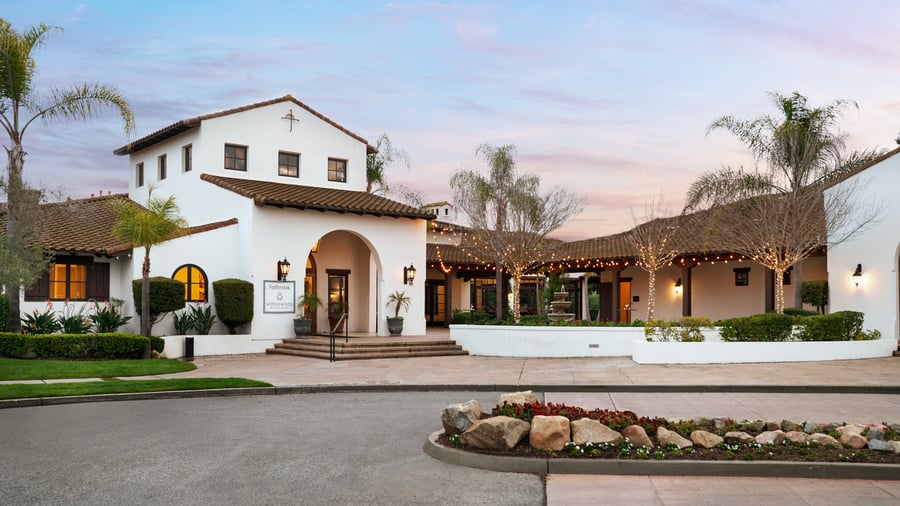 Spanish colonial style event venue exterior at Fallbrook Estate by Wedgewood Events featuring terracotta tile roof, white stucco walls, arched entrance and string lighting for corporate events and private celebrations