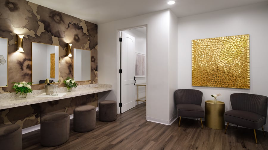 Sophisticated event preparation room at Fallbrook Estate by Wedgewood Events featuring modern vanity area, gold accent wall, comfortable seating and premium amenities for corporate events and celebrations