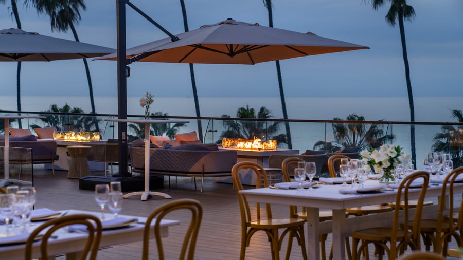 Lounge seating with fire features and umbrellas overlooking coastline