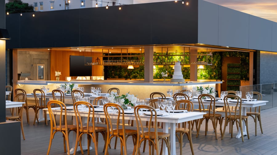 Evening venue overview showing kitchen, dining areas and string lighting
